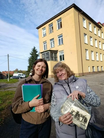 Две участницы экскурсии, одна из них держит архивную фотографию